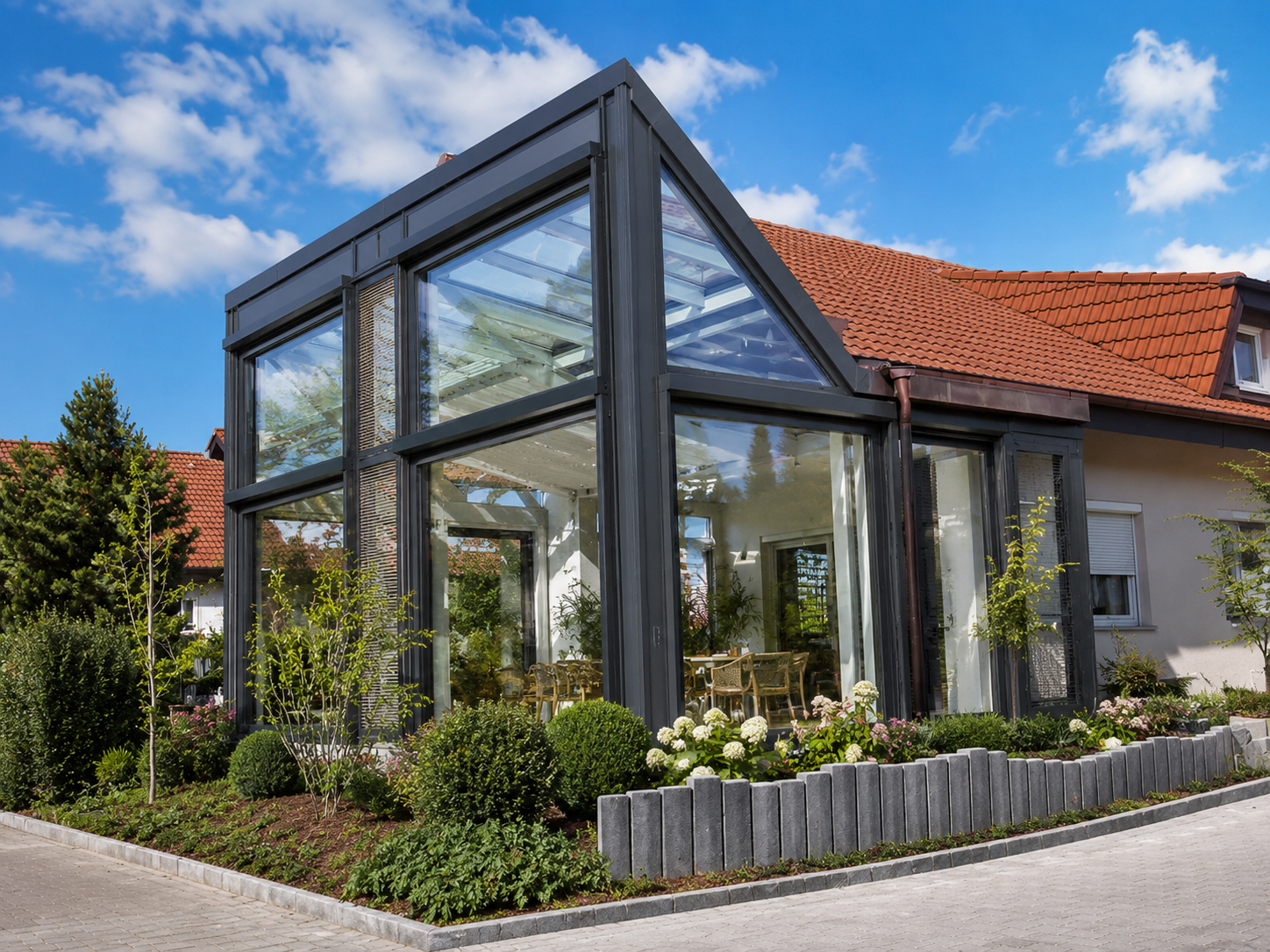 Grauer Aluminium-Wintergarten mit großer Glasfront im Garten